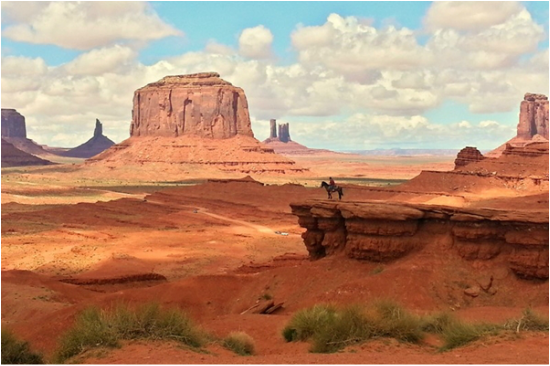 a Navajo sitting on his horse looking out over Monument Valley, Arizona